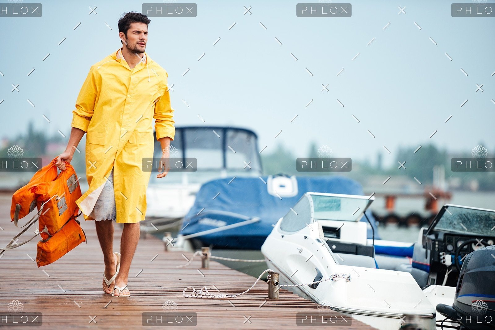 demo-attachment-32-sailor-in-yellow-cloak-at-the-pier-holding-life-PX7M94D
